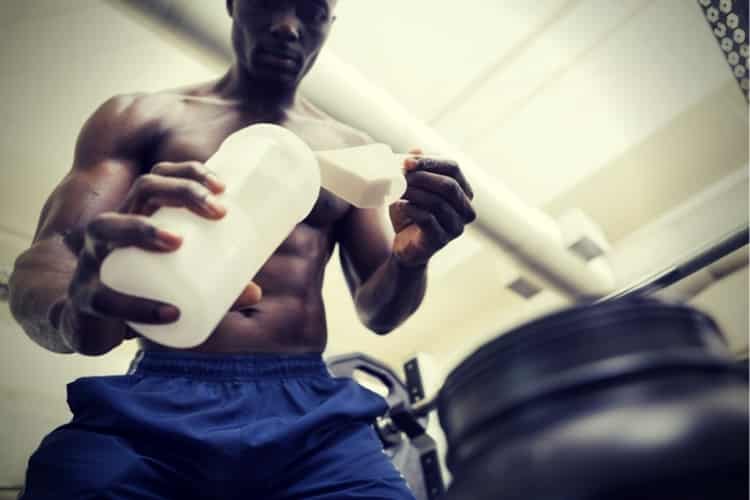 Body builder scooping up protein powder Body builder scooping up protein powder