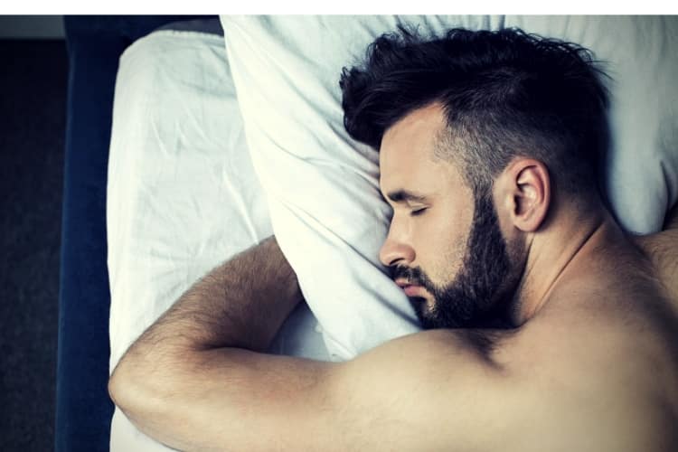 Close-up view of man sleeping in bed