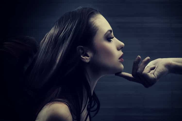 Conceptual image of a hand holding a womans head Conceptual image of a hand holding a womans head