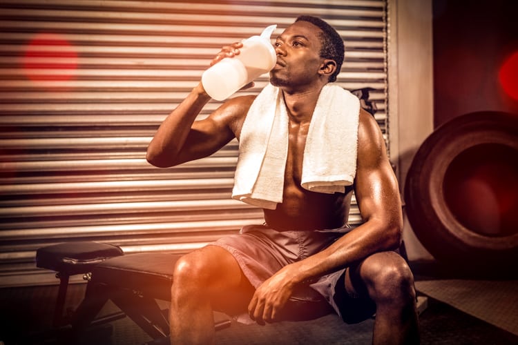 Shirtless man drinking protein shake