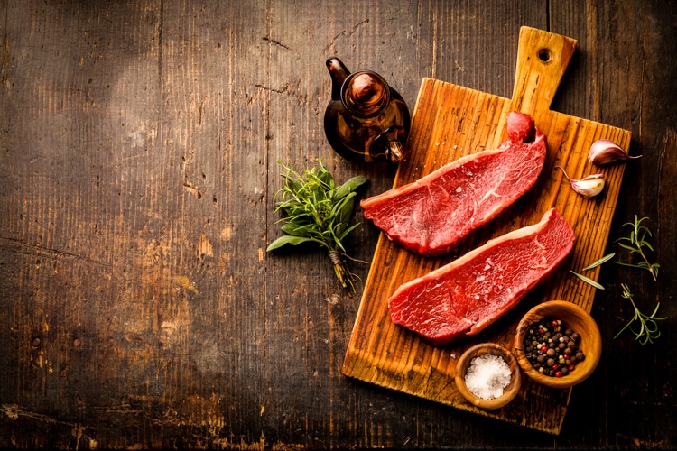 Raw fresh meat Striploin steak and seasoning on dark wooden back
