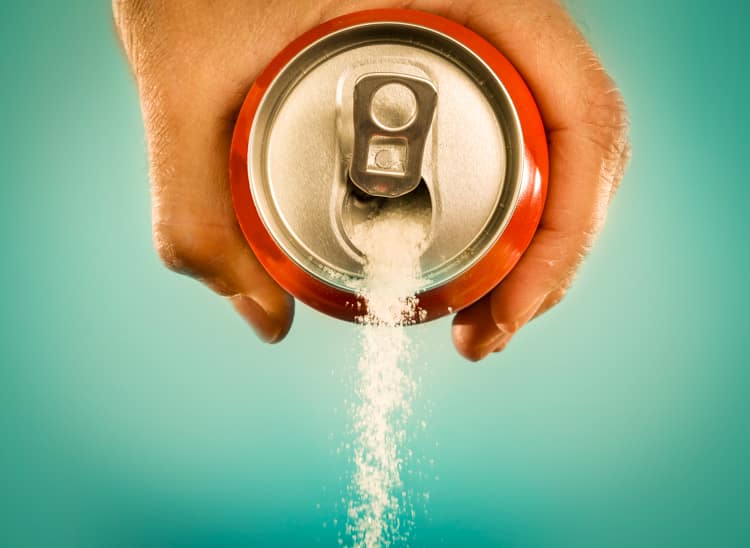 hand holding soda can pouring a crazy amount of sugar in metapho