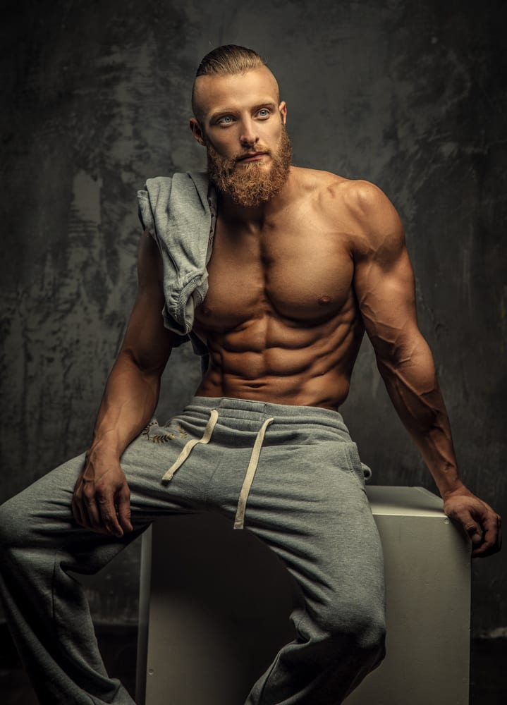 Portrait of muscular shirtless man with beard.