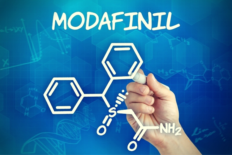 Hand with pen drawing the chemical formula of Modafinil Hand with pen drawing the chemical formula of Modafinil
