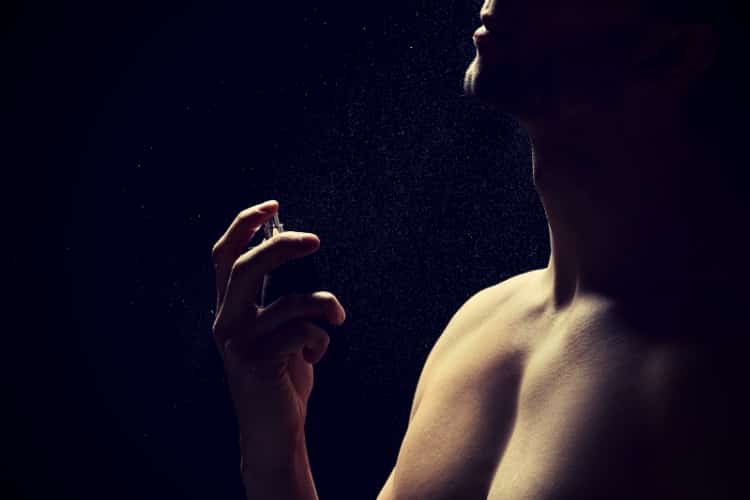 Handsome man using perfume