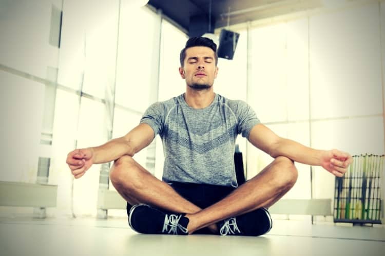 Man meditating in fitness gym Man meditating in fitness gym