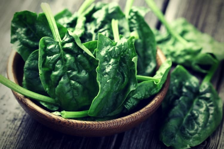 Spinach leaves in a wooden plate Spinach leaves in a wooden plate