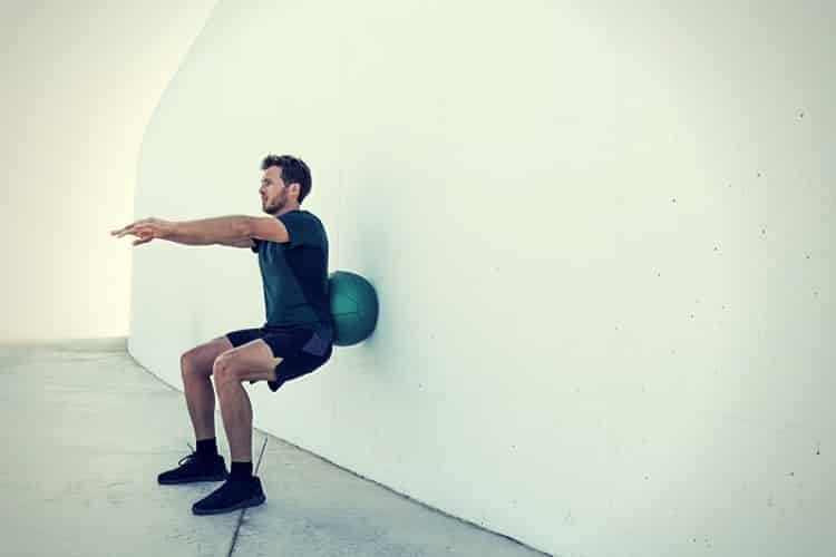 Strength training man doing medicine ball squats. Strength training man doing medicine ball squats.