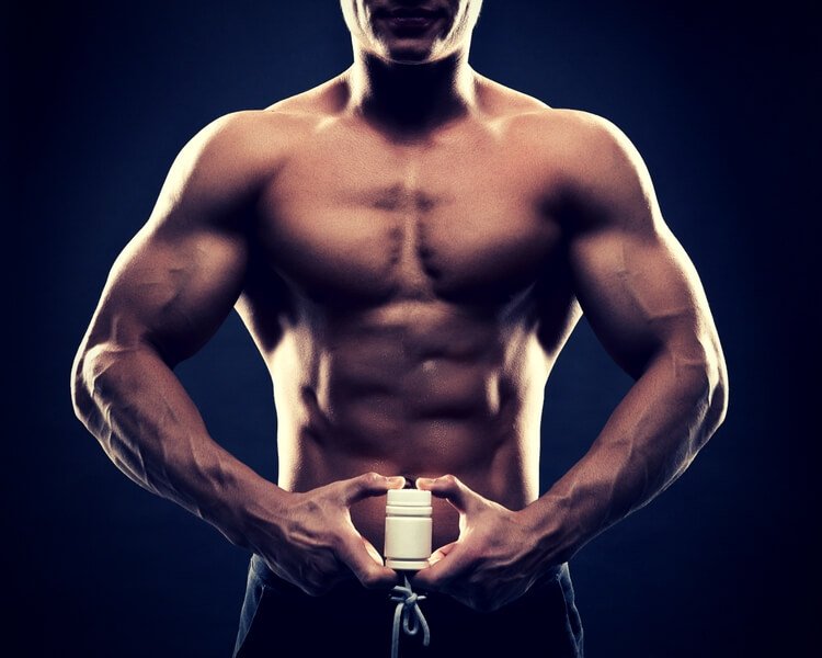 bodybuilder holding a white jar of pills bodybuilder holding a white jar of pills