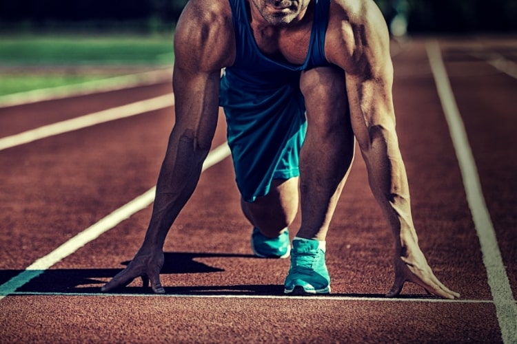 Young muscular athlete is at the start of the treadmill Young muscular athlete is at the start of the treadmill