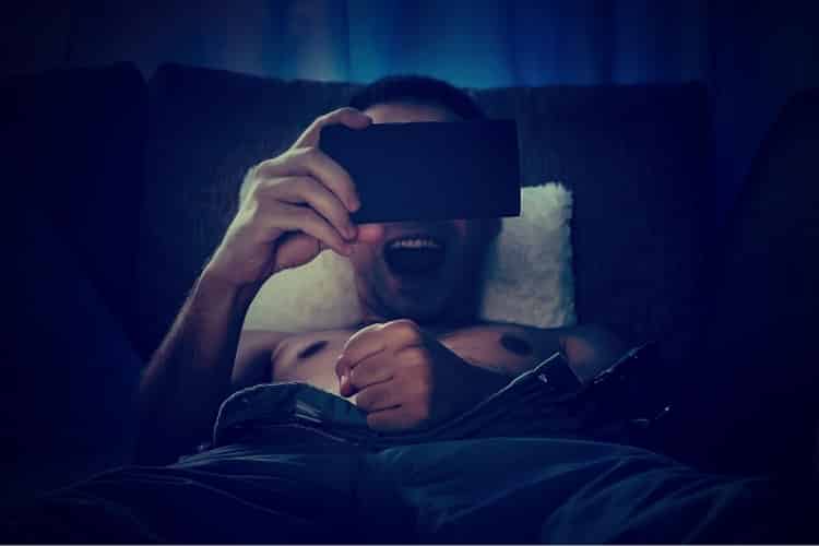 Young naked man watching pornography