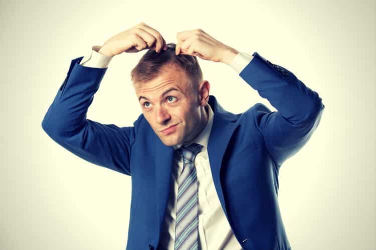 businessman indicating hair loss businessman indicating hair loss
